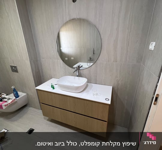 שיפוץ חדר אמבטיה כולל חיפוי אריחים גדולים, ארון רחף וכיור מונח